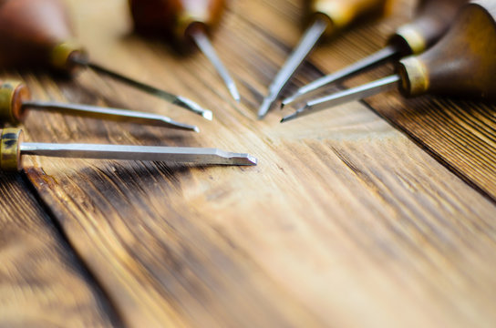 Different gravers for jewelry on wooden background