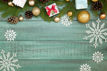Christmas background or Xmas card  with decorations fir branches, pine cones, gift box on the wooden green backtop. Space for holiday text. Postcard  vintage style. Top view and flat