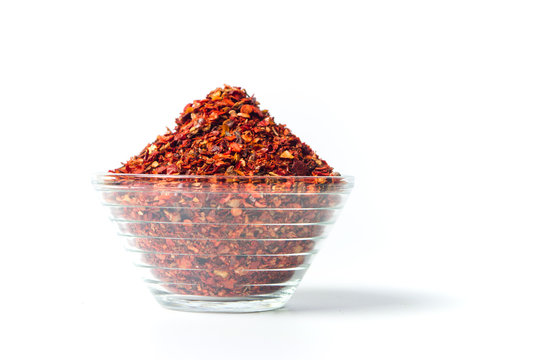 Smashed red pepper powder in a bowl isolated