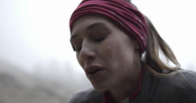 Athlete girl resting after run. Detail on face breathing.Real people woman runner sport training in autumn or winter in wild mountain outdoors nature, bad foggy weather.4k 60p slow motion video