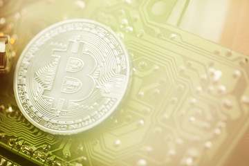 silver Bitcoin virtual currency coin on a circuit board background