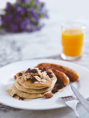 Breakfast Pancake and Sausage Top with Almond and Raisin on white plate