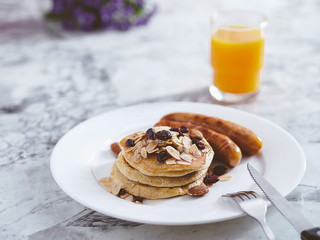 Breakfast Pancake and Sausage Top with Almond and Raisin on white plate