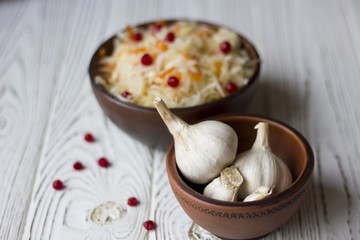 sauerkraut and garlic in a clay plate on wooden table