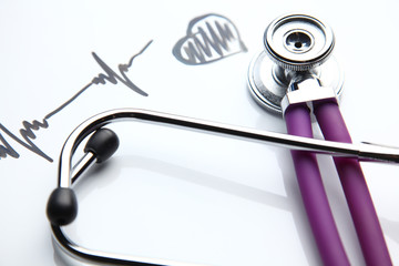 Stethoscope with cardiogram lying on desk in hospital
