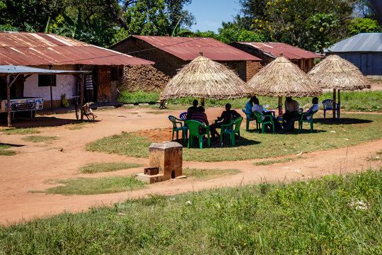 A nice little bar along the road from Mbale to Soroti in Uganda. People relaxing in the shade of a traditional hut and drinking a coke.