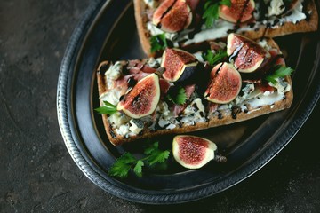Sandwich of chiabaha, soft cheese, blue cheese, ham parma, figs and balsamic cream. Top view.