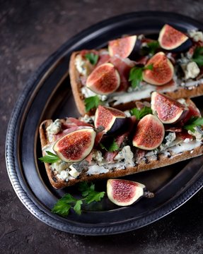 Sandwich of chiabaha, soft cheese, blue cheese, ham parma, figs and balsamic cream. Top view.