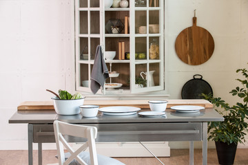 modern metal table in the decorated white kitchen cupboard