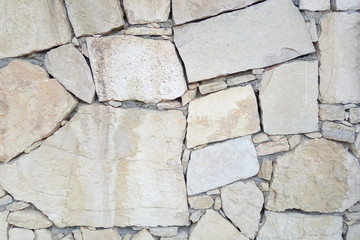 Old stone wall. Uneven rough stones of different shapes. Stone background. 