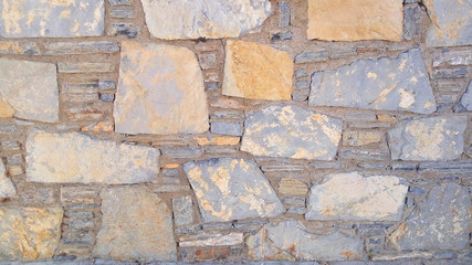 Old stone wall. Uneven rough stones of different shapes. Stone background. 