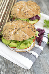 Sandwiches with avocado, camembert, vegetable salad and salami. Breakfast on the rustic table.