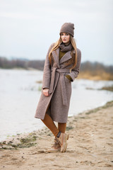 girl in a knitted cap and scarf in the autumn on nature. cold.