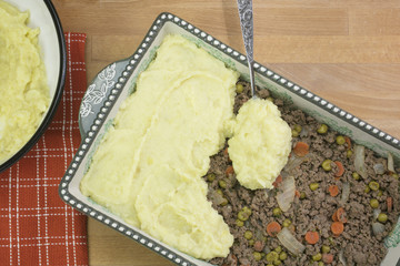 Food preparation of Shepherd's Pie made with ground beed, vegetables and mashed potatoes