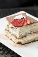 Italian Tiramisu made with chocolate and layers of cake and cream, topped with strawberries