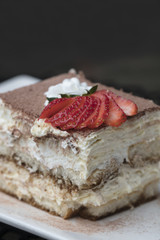 Italian Tiramisu made with chocolate and layers of cake and cream, topped with strawberries
