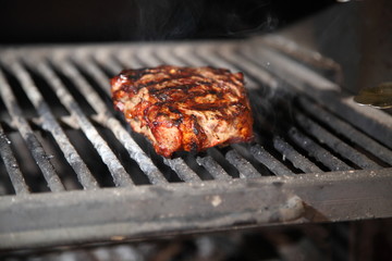 Preparation of steak on the grate and coals.