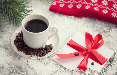 hot coffee, red warm pullover and gift with a red bow on a snowy background