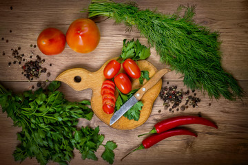 Sliced cherry tomatoes, vegetables and seasonings, parsley, dill, garlic. preparation for cooking