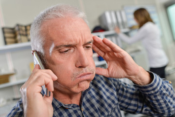 Man on telephone, looking stressed