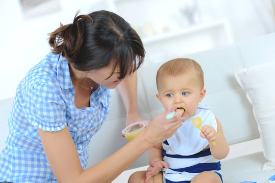 mom feeds the baby fruits pure