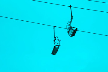 Blue toned photography of the two empty chair lift sits