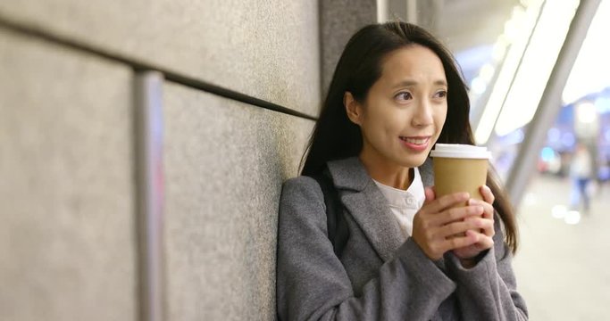 Woman feeling cold outside hold with hot coffee cup in city
