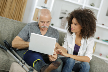 injured old man using laptop