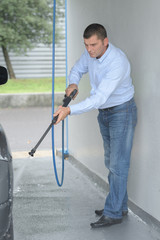 man washes foam machine at the station