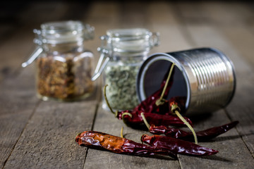 Dried pepper in a metal tin on a wooden kitchen table. Red hot pepper and spices in the kitchen.