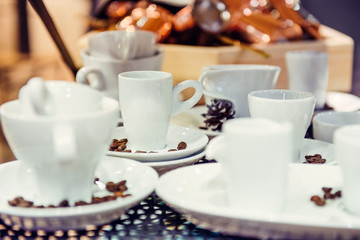 Variety of different forms of coffee cups on the metal background in exhibition presentation. Soft selective focus