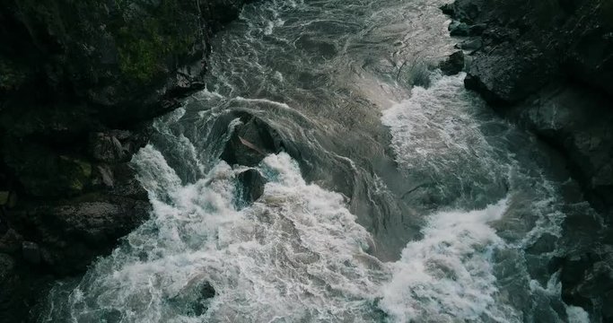 Mountain river. Water flow in a mountain gorge, aerial view. (not graded 4K D-cinelike footage)