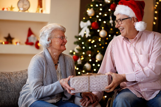 smiling senior couple with Christmas gift.