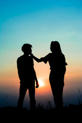 Fototapeta na wymiar silhouette of romantic couple at the sunset time on meadow. Have a beauty pink and blue sky.