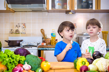 Healthy eating. Happy children prepares and eats vegetable salad in kitchen