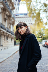 Fototapeta premium Closeup portrait of effective girl smiling to camera on Paris street on with Eiffel background.