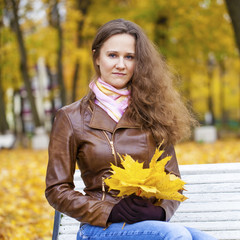Young beautiful woman in autumn park