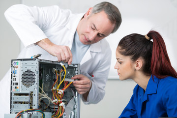 female repairing computer in technical school