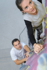 sporty male and female climbing on an indoor climbing wall