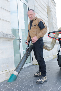 street cleaner works with a vacuum cleaner on the street