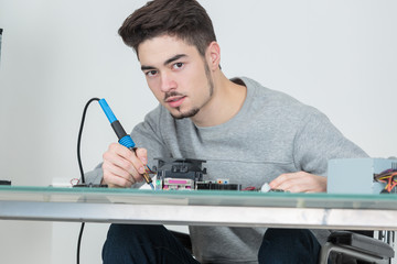 young man holding soldering iron