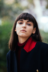 young beautiful brunette woman portrait with short hairs in coat on the Paris streets