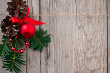 Christmas decorations with evergreen tree twigs, pine cone, red ball and wooden peg clips in form of star. 
