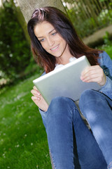pretty student using digital tablet outdoors