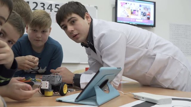 Shot of cute kids building motorized robot at elementary school