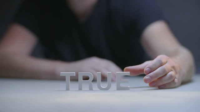 Male hands composition word true by white letters on gray background