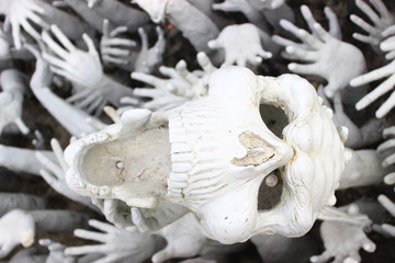 Naklejka premium Abstract sculpture of white skull and hands.