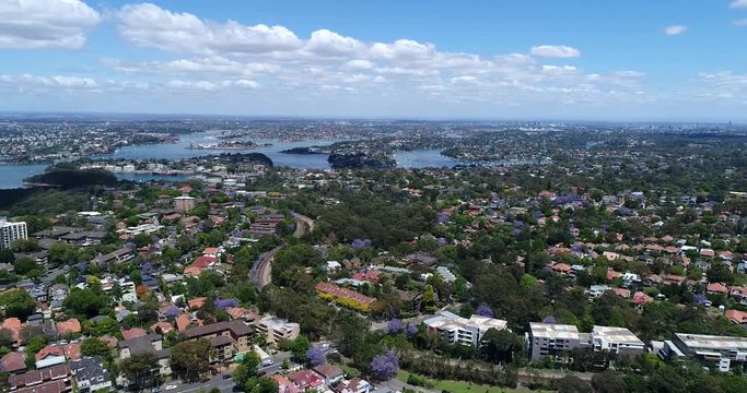 Panorama of the Greater Sydney from Lower north shore residential suburbs with waters of Harbour, city CBD, Harbour Bridge and distant pacific coast.
