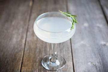 Tasty cocktail with rosemary on the rustic background. Shallow depth of field. Selective focus.