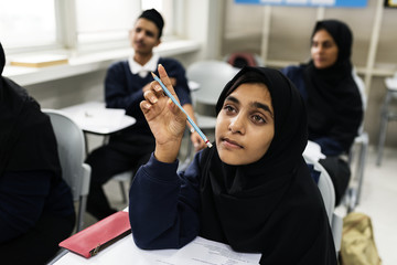 diverse muslim children studying in classroom